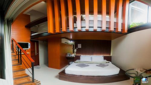a bedroom with a bed in a room with a staircase at Ricci House Resort in Ko Lipe