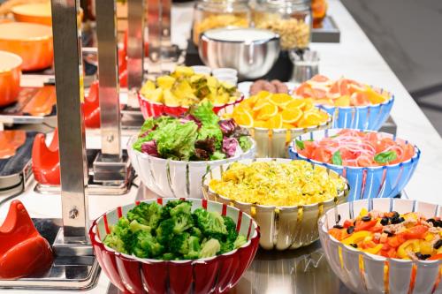 a buffet filled with bowls of different types of food at HOTEL FORZA SAPPORO STATION in Sapporo