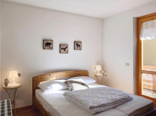 1 dormitorio con 1 cama y 2 cuadros en la pared en Appartamento il Sole, en Ponte di Legno