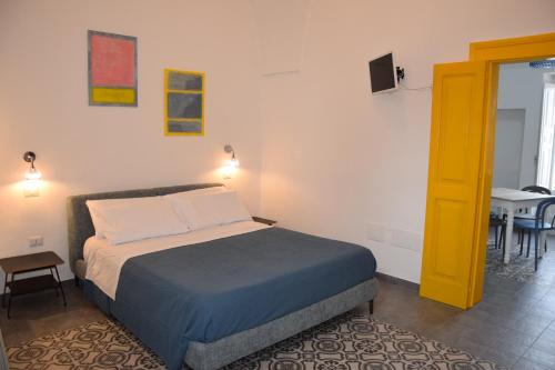 a bedroom with a bed with a yellow door and a table at Palazzo Rimesa in Cutrofiano