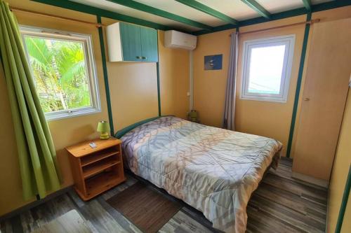 niewielka sypialnia z łóżkiem i oknem w obiekcie Maison à Saint-leu, vue exceptionnelle sur la baie et l'Océan à 2 minutes des plages w mieście Saint-Leu