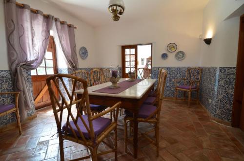 a dining room with a wooden table and chairs at Idyllic Farm House Amazing Landscap Sea View in Loulé