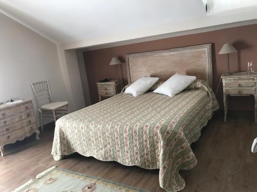 a bedroom with a bed with two night stands and two tables at Albus Albi in Colmenar del Arroyo