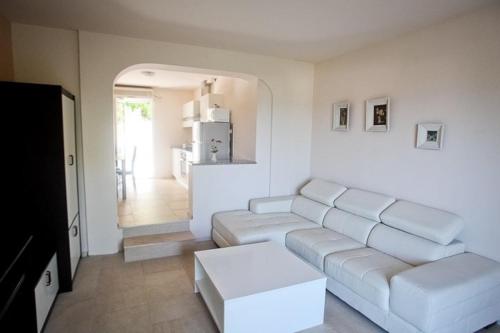 a living room with white couches and a kitchen at Apartments Kalaba - Dalma II in Podaca