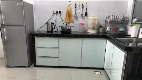 a kitchen with a black counter and a refrigerator at Taiping Rain Town Homestay太平雨城名宿 two car park in Taiping