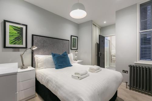 a bedroom with a large bed with towels on it at Urban Chic - Wellington in London