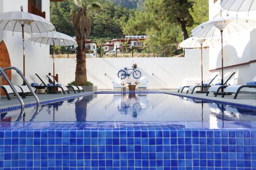 a swimming pool with chairs and a bike in the middle at Alp Suites Pinehill in Akyaka