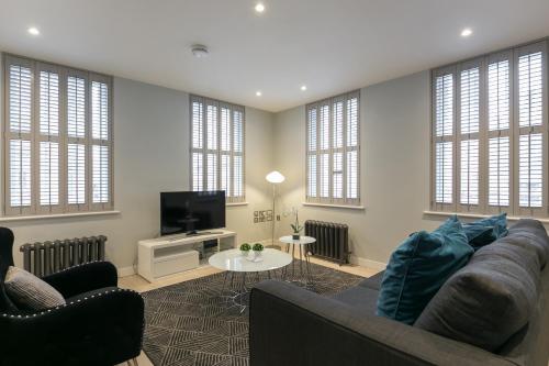 a living room with a couch and a tv at Urban Chic - Wellington in London