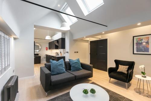 ein Wohnzimmer mit einem Sofa und 2 Stühlen in der Unterkunft Urban Chic - Wellington in London