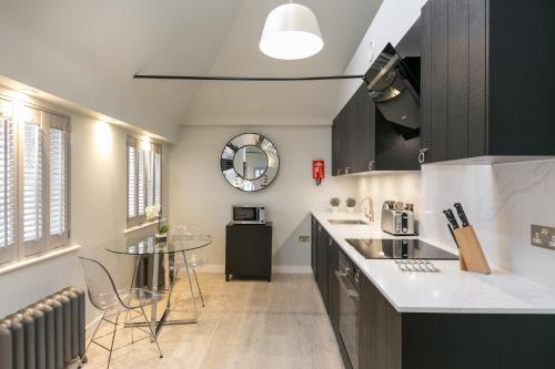a kitchen with a counter and a table in it at Urban Chic - Wellington in London