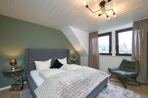 a bedroom with a bed and a green chair at Ferienhaus Wehlener Rosengarten in Bernkastel-Kues