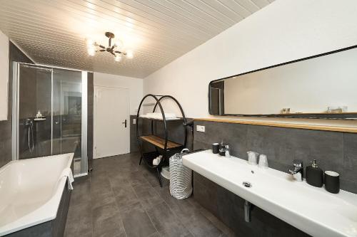 łazienka z 2 umywalkami i dużym lustrem w obiekcie Ferienhaus Wehlener Rosengarten w mieście Bernkastel-Kues