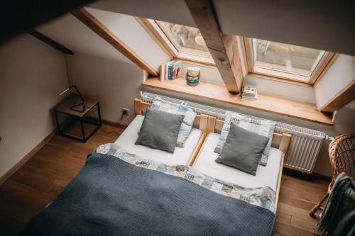 an attic bedroom with a bed and a window at Villa Hubertus in Srebrna Góra