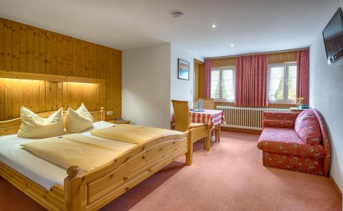 a bedroom with a large bed and a chair at Hotel Zum Löwen - Unteres Wirtshaus in Titisee-Neustadt