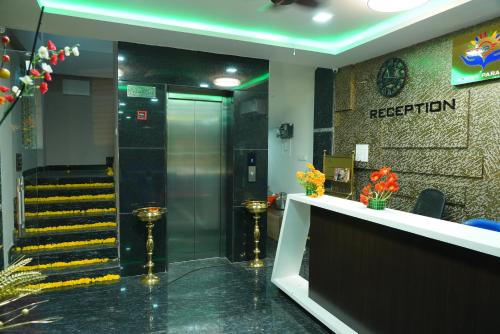 a lobby with an elevator and stairs in a building at Yashas Paradise in Nanjangūd