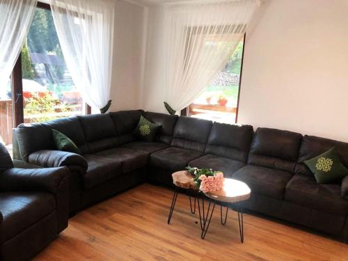 a living room with a black couch and a table at Blumenhof Bucovina in Voronet