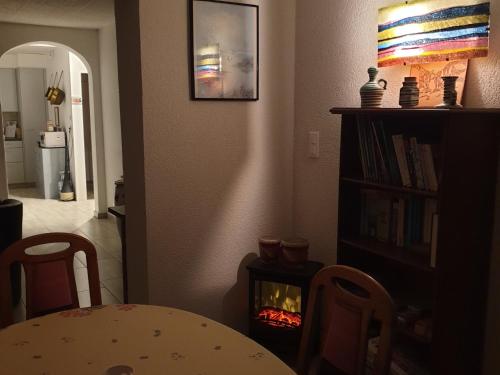 a living room with a table and a fire place at Appartement d'hôtes An Kaz La in Crans-Montana
