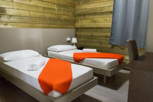 2 camas individuais num quarto com paredes de madeira em Policoro Village Hotel em Policoro