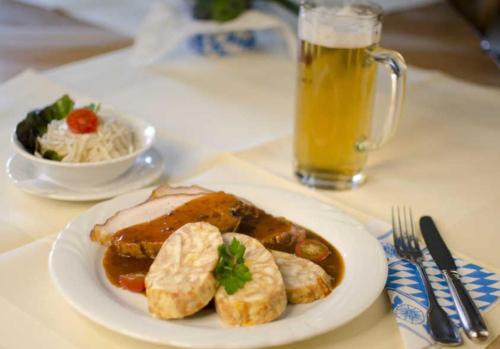 um prato de comida e um copo de cerveja numa mesa em Zum Goldenen Schwanen em Frankenried