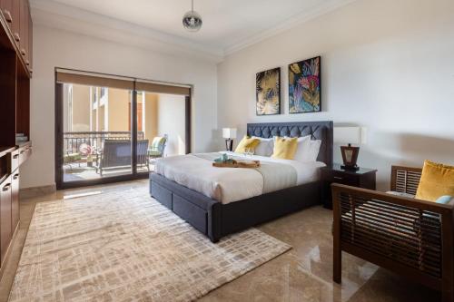 a bedroom with a large bed and a balcony at Frank Porter - Fairmont Palm Residences in Dubai