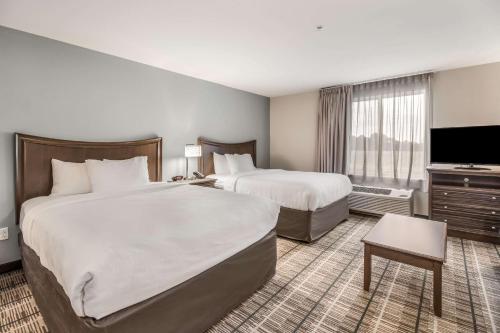 um quarto de hotel com duas camas e uma televisão de ecrã plano em MainStay Suites em Union City