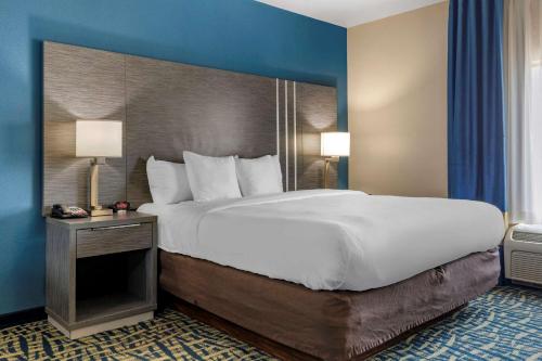 een slaapkamer met een groot bed en een blauwe muur bij Comfort Inn & Suites Pauls Valley - City Lake in Pauls Valley