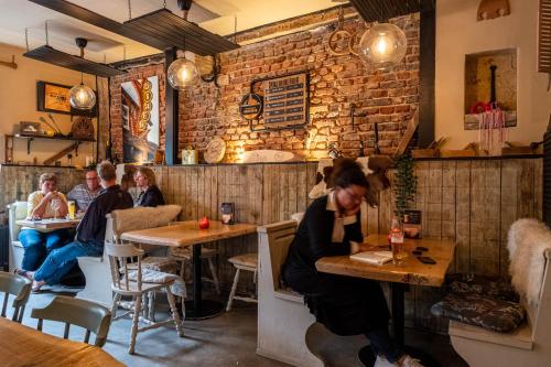 a group of people sitting at tables in a restaurant at Den oude Herberg in Hulsberg
