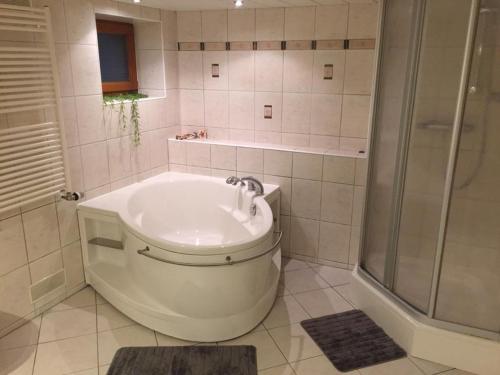 La salle de bains blanche est pourvue d'une baignoire et d'une douche. dans l'établissement Haus Bergblick, à Luftkurort Lückendorf