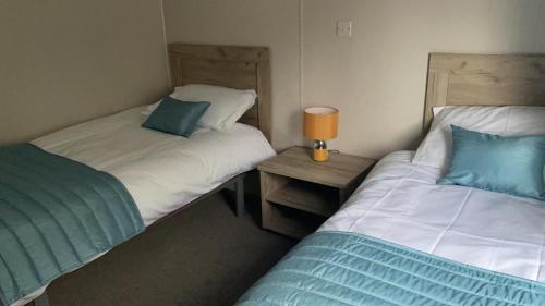 WartonにあるRambells Lodgeのベッド2台が隣同士に設置された部屋です。