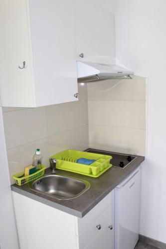 a kitchen sink with a yellow tray next to it at Filipovic Apartmani in Medulin
