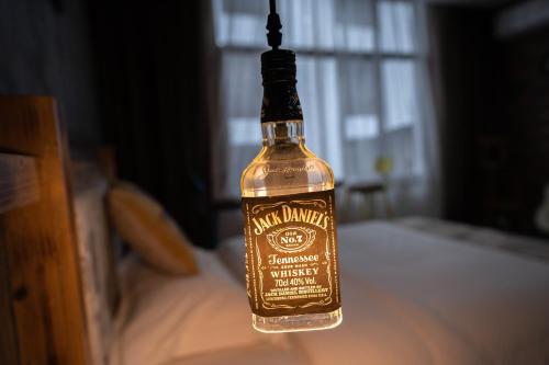 a bottle of whiskey hanging on a bed at Zhangjiajie Highlights Guesthouse in Zhangjiajie