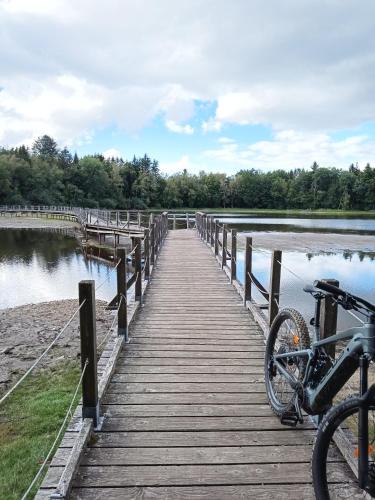 a bike parked on a wooden bridge over a lake at Le Gite des Deux Lacs Settons in Planchez