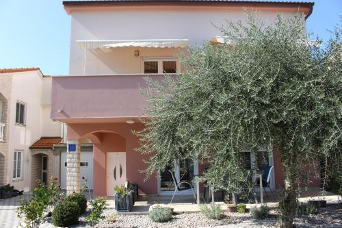 a house with a tree in front of it at Filipovic Apartmani in Medulin