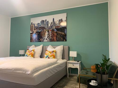 a bedroom with a bed with a painting on the wall at ARGENTA Living 2 in Fulda