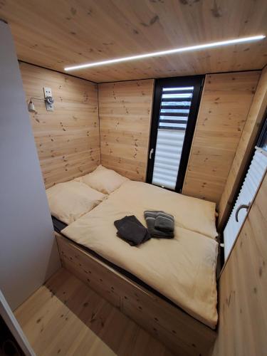 a small bed in a small room in a wooden cabin at Hausboot Geiselruh in Braunsbedra