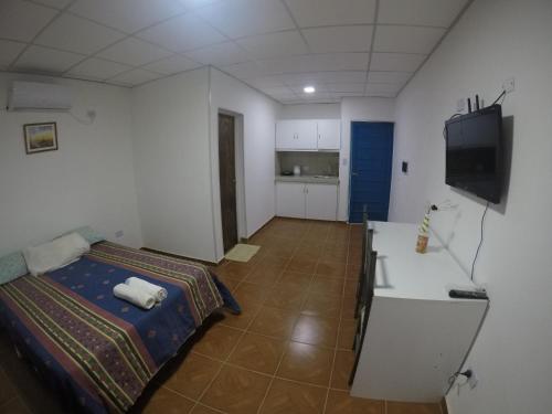 Cette chambre comprend un lit et une télévision. dans l'établissement RESIDENCIAL SIC, à Aimogasta