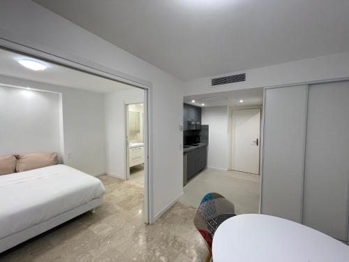 une chambre blanche avec un lit et un miroir dans l'établissement Petit 2 pièces Carré d'Or, à Nice