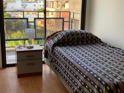 a bedroom with a bed and a nightstand and a window at TRESOR in San Luis