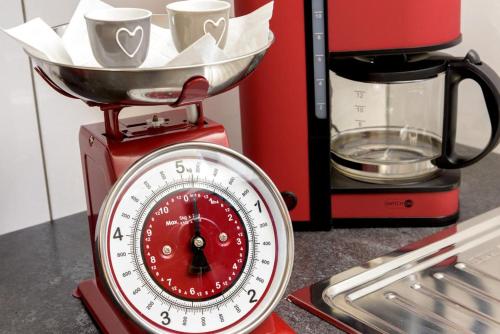 a red kitchen scale with a bowl on top of it at Haus am Weißenbach in Bad Hindelang