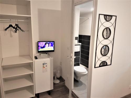 łazienka z toaletą i telewizorem w obiekcie NancyRoom w mieście Vandœuvre-lès-Nancy