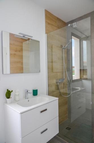 a bathroom with a white sink and a shower at MAAR House Lajares in Lajares