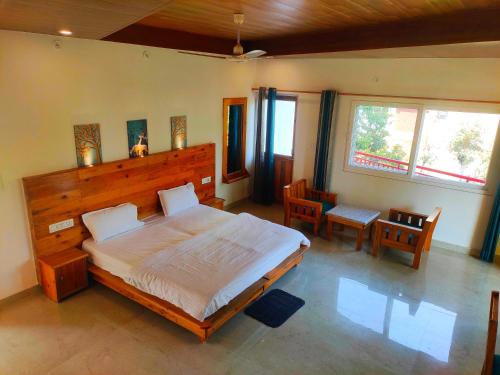 sypialnia z dużym łóżkiem, stołem i krzesłami w obiekcie Hill Hoppers Hotel w mieście Rishikesh