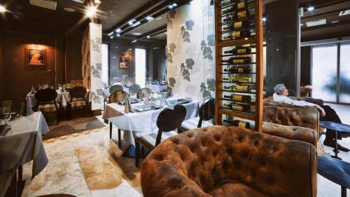 a restaurant with a man sitting at a table in a room at Hotel Paradis in Cluj-Napoca