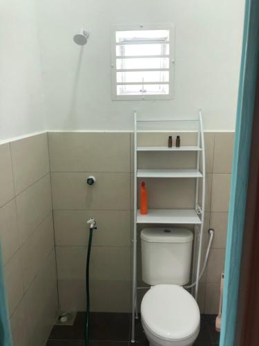 ein Bad mit einem weißen WC und einem Fenster in der Unterkunft Homestay Warisan Nenda in Shah Alam