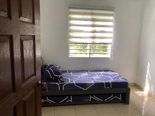 a bed sitting in a room with a window at Homestay Warisan Nenda in Shah Alam