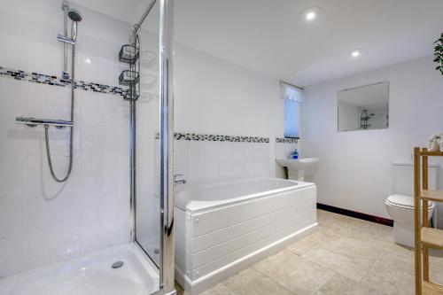 a bathroom with a shower and a tub and a toilet at The Barn in Felbrigg