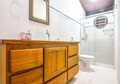 a bathroom with a sink and a toilet and a mirror at Pouso Caminho das Artes in Cunha
