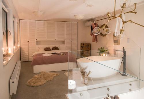 een badkamer met een bad en een bed bij Hedo & Art Loft - Old Town in Poznań