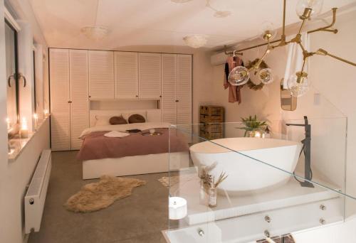 a bathroom with a bath tub and a bed at Hedo & Art Loft - Old Town in Poznań