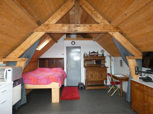 sypialnia z łóżkiem i biurkiem na poddaszu w obiekcie Studio with More than a View w mieście Maldegem